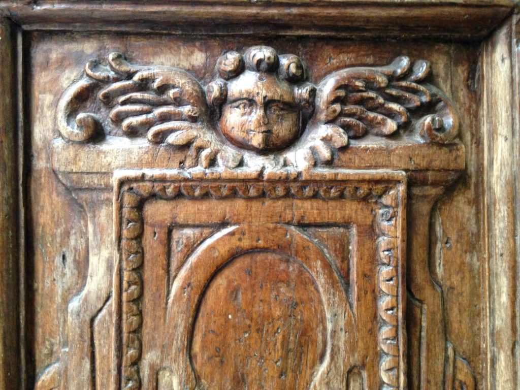 Intarsio in legno portone di ingresso, chiesa sconsacrata Firenze, Putto in legno